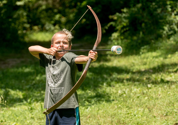 Child draws his bow at Asheville summer day camp for archery