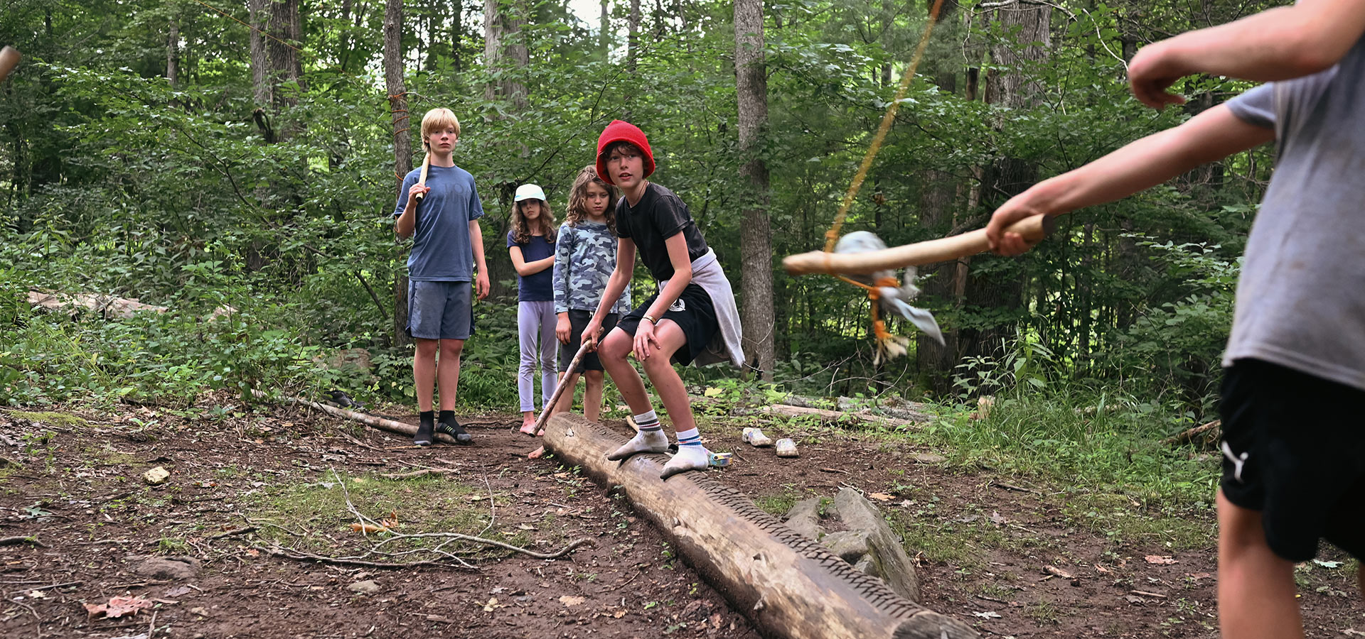 Children testing balance and feigning swordplay at the Forest Floor jedi training center