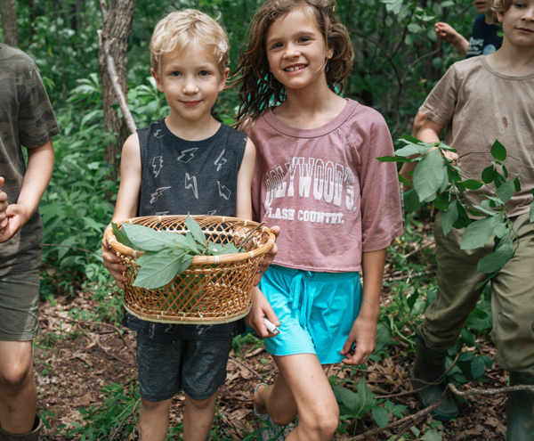 Children hold basket while foraging in the Blue Ridge at Asheville homeschool activity