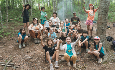 Homeschool kids take a break during a fun day in the woods near Asheville