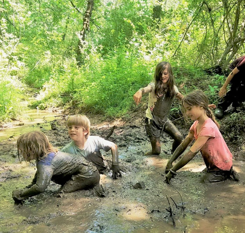 Kids at nature camp playing in the mud