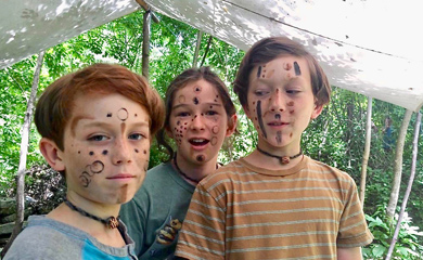 Kids with tribal face paints at forest school program for homeschool children