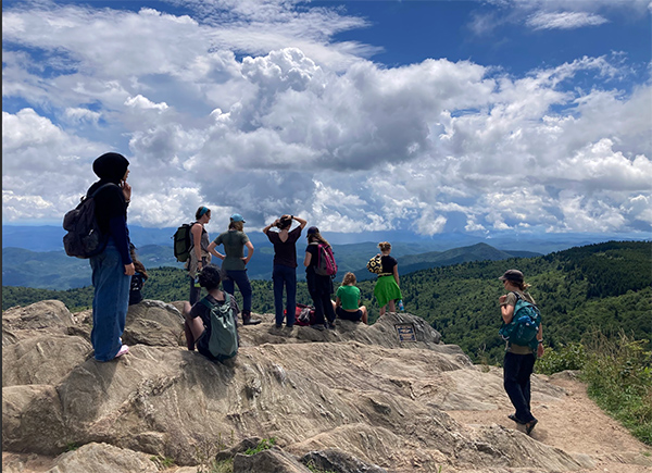 Group of teenage homeschoolers on a rocky mountain overlook after hiking at Teen Adventures homeschool program